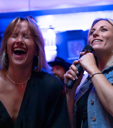 Deux femmes chantant lors d'une soirée karaoké