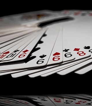 Cartes à jouer étalées sur une table noire, illustrant un jeu de cartes de type poker ou blackjack